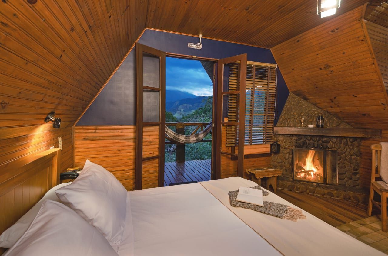 Um quarto com lareira e uma cama grande