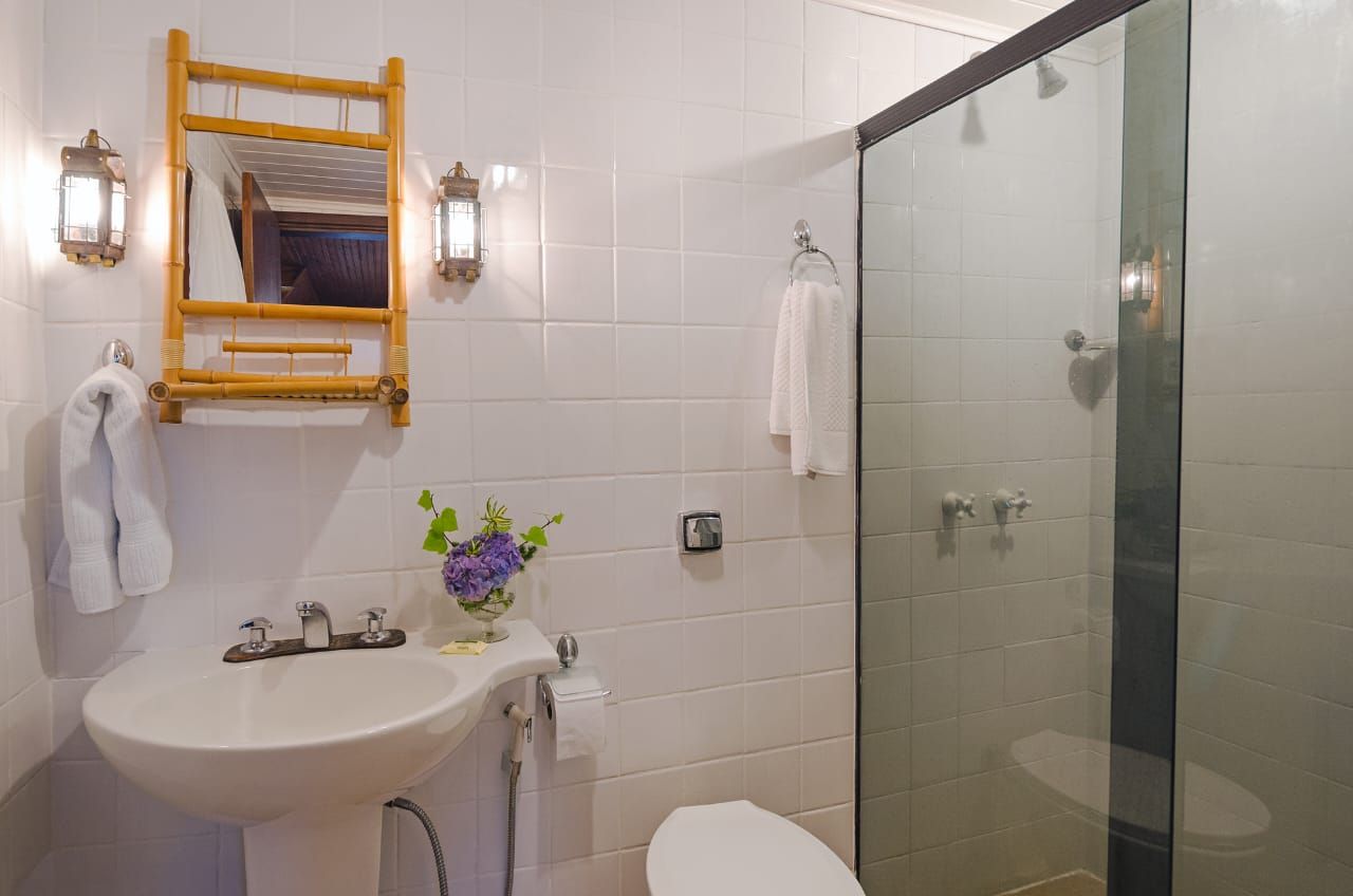 Um banheiro com pia, vaso sanitário e chuveiro.