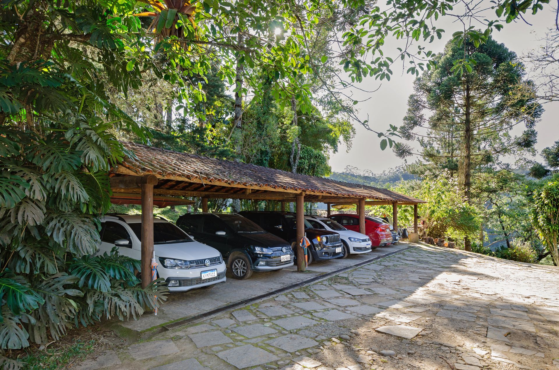 Uma fileira de carros está estacionada sob um teto de madeira em um estacionamento.