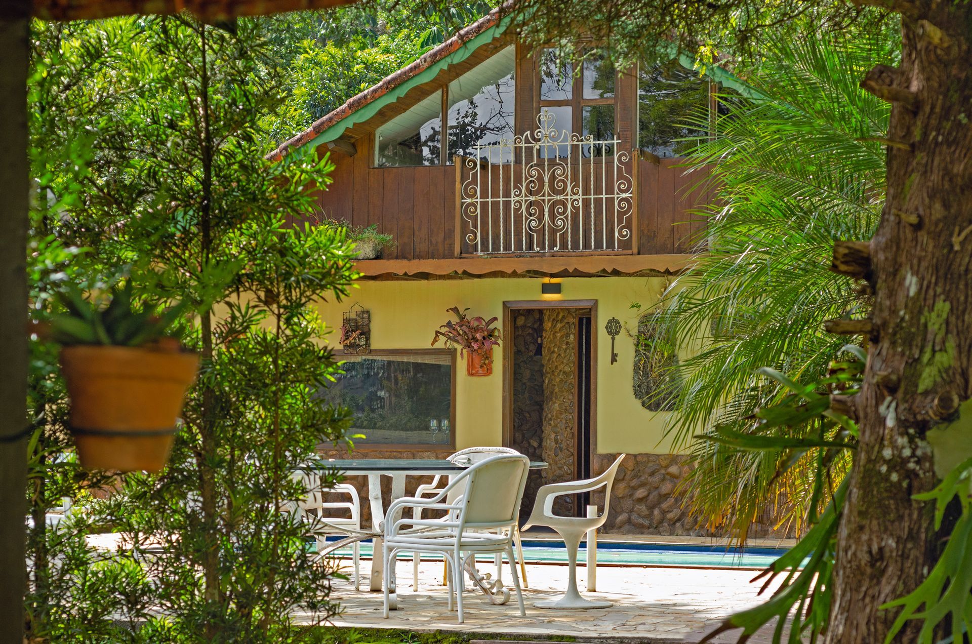 Uma casa com piscina é cercada por árvores
