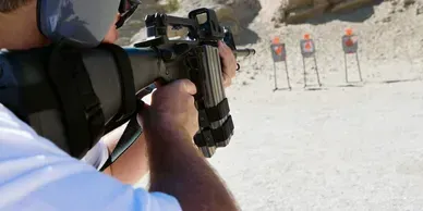 Person aiming a gun at targets on a firing range.