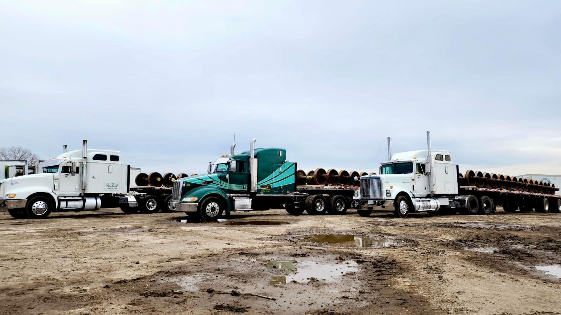 A semi truck is driving down a road with a trailer attached to it.