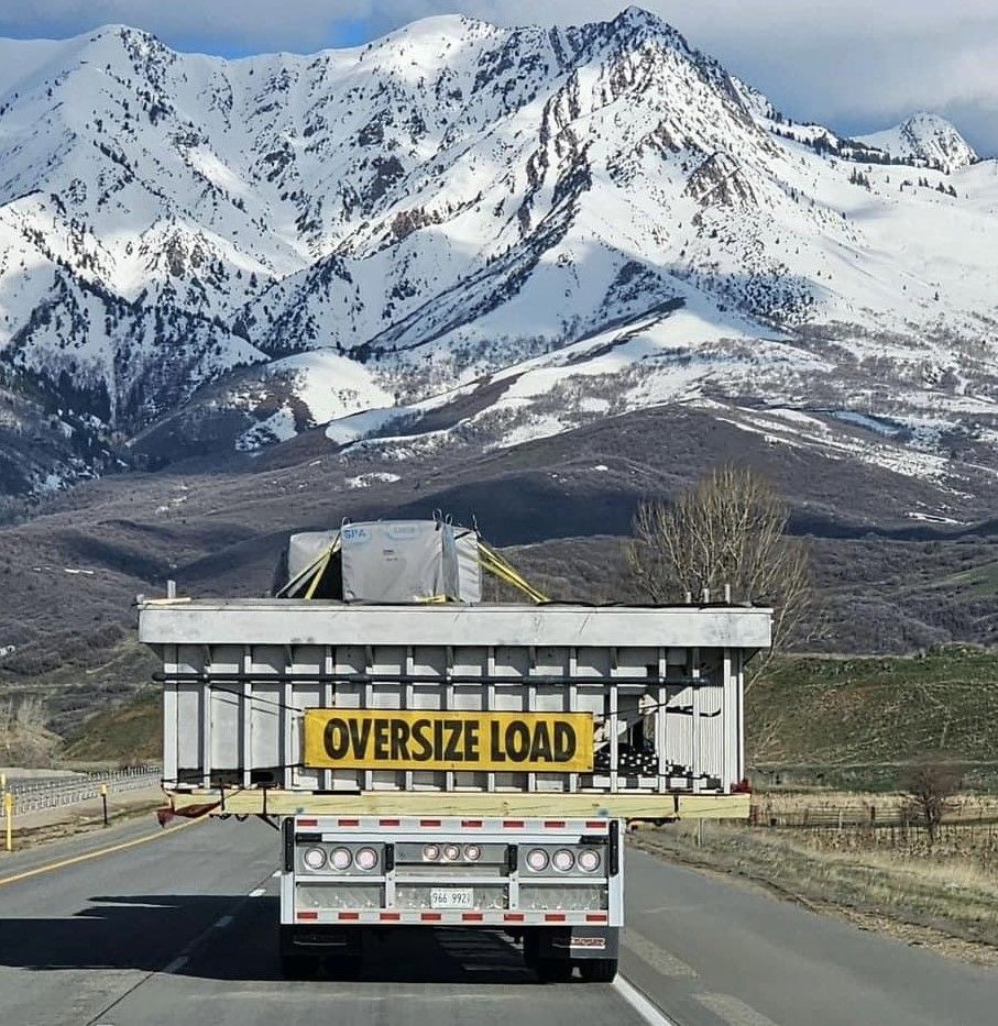 An oversize load truck is driving down the road