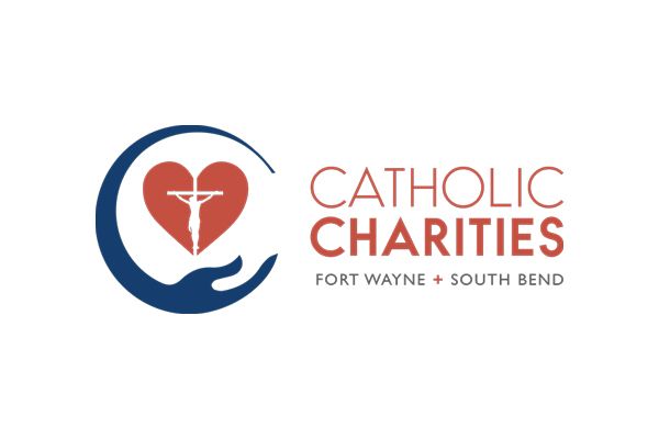 Catholic Charities logo: Heart with crucifix within blue embrace. Text: Catholic Charities Fort Wayne + South Bend.