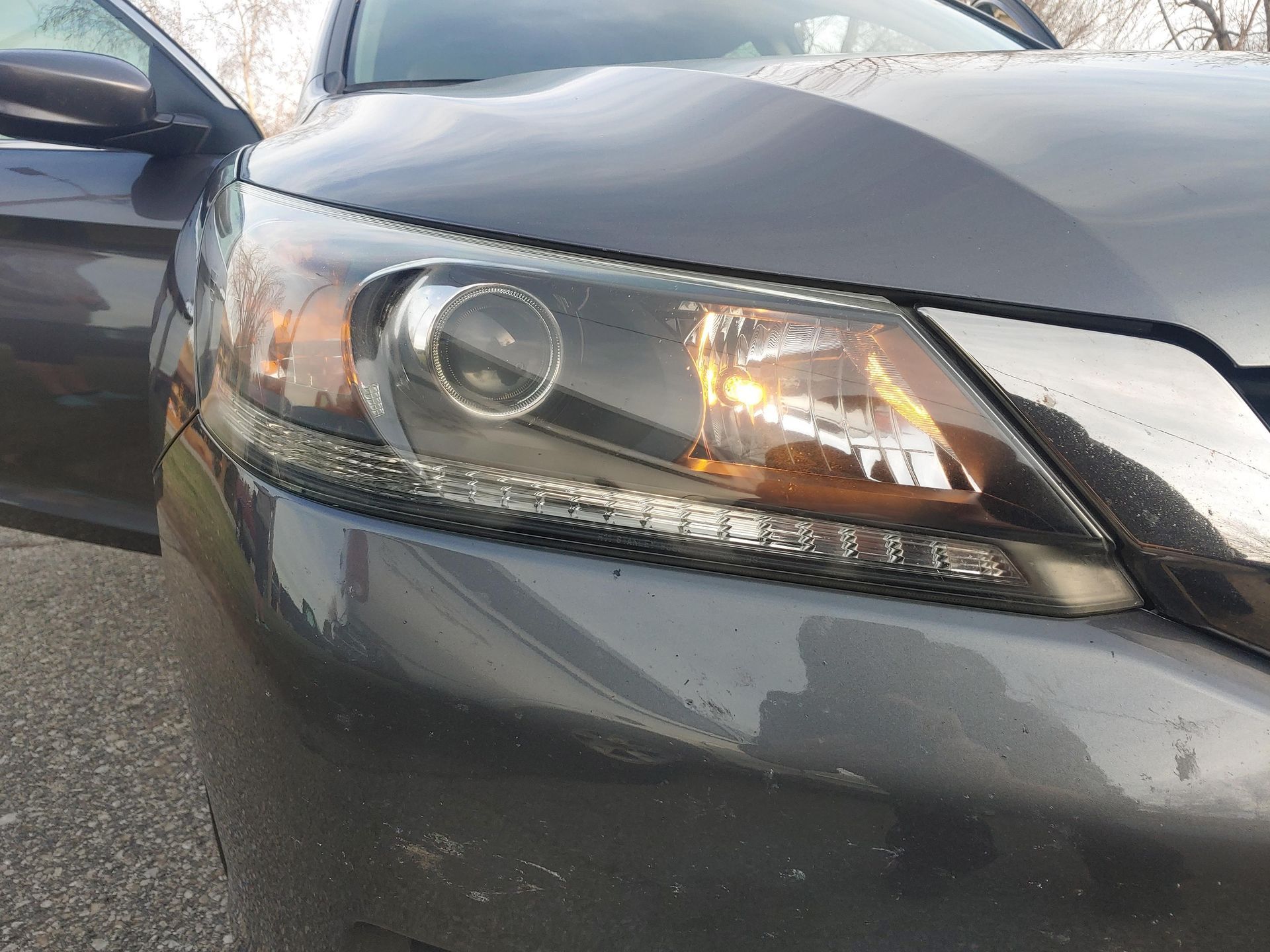 Auto Detailing - A close up of a car 's headlight with the door open.