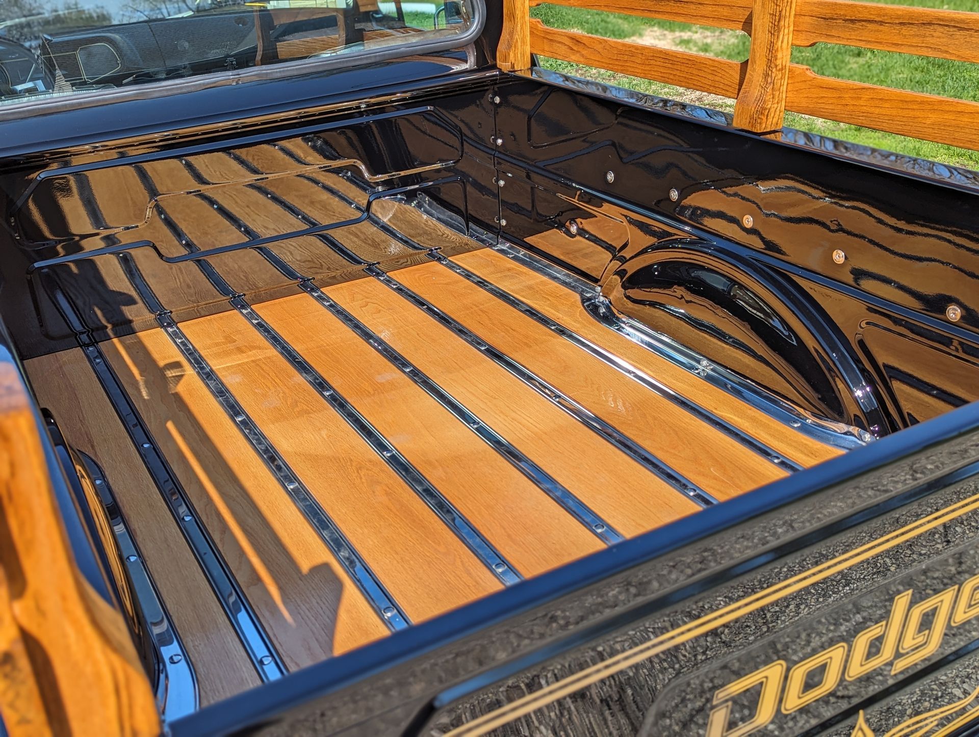 The back of a dodge truck with a wooden bed