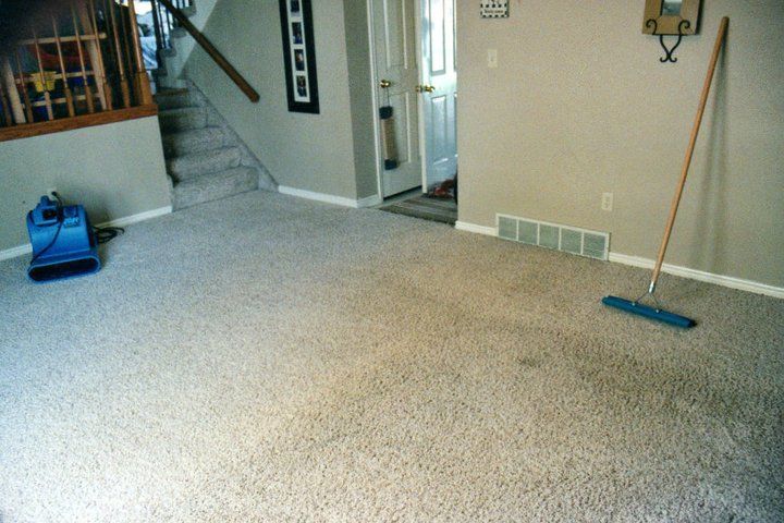 A room with a staircase and a broom on the floor