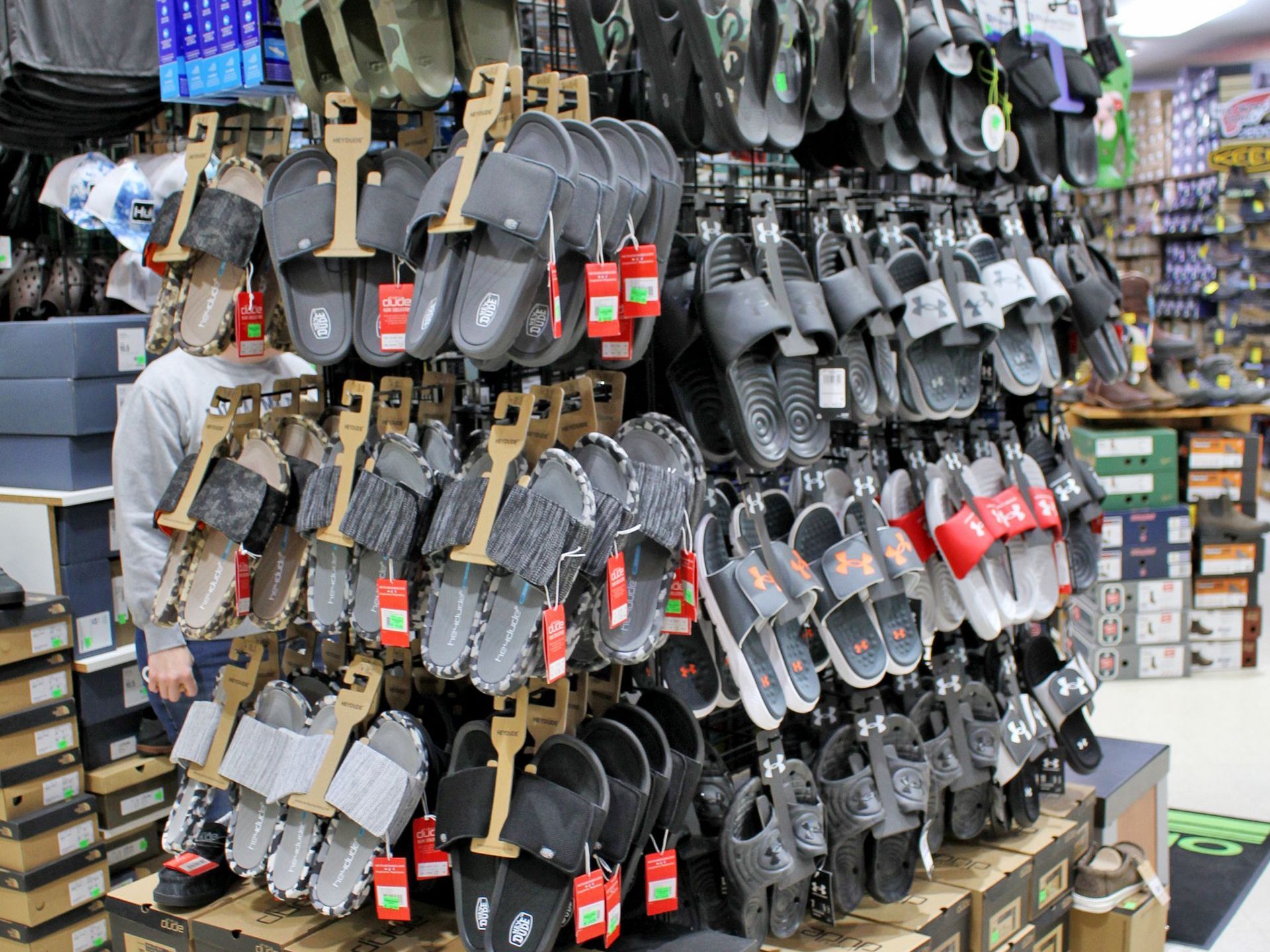 Display of various sandals and slides for sale in a retail store.