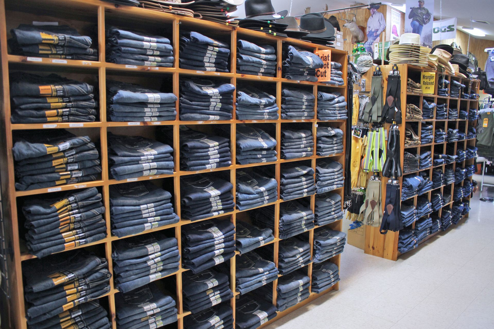 Shelves packed with folded jeans in a clothing store. Wooden shelves in a well-lit space.
