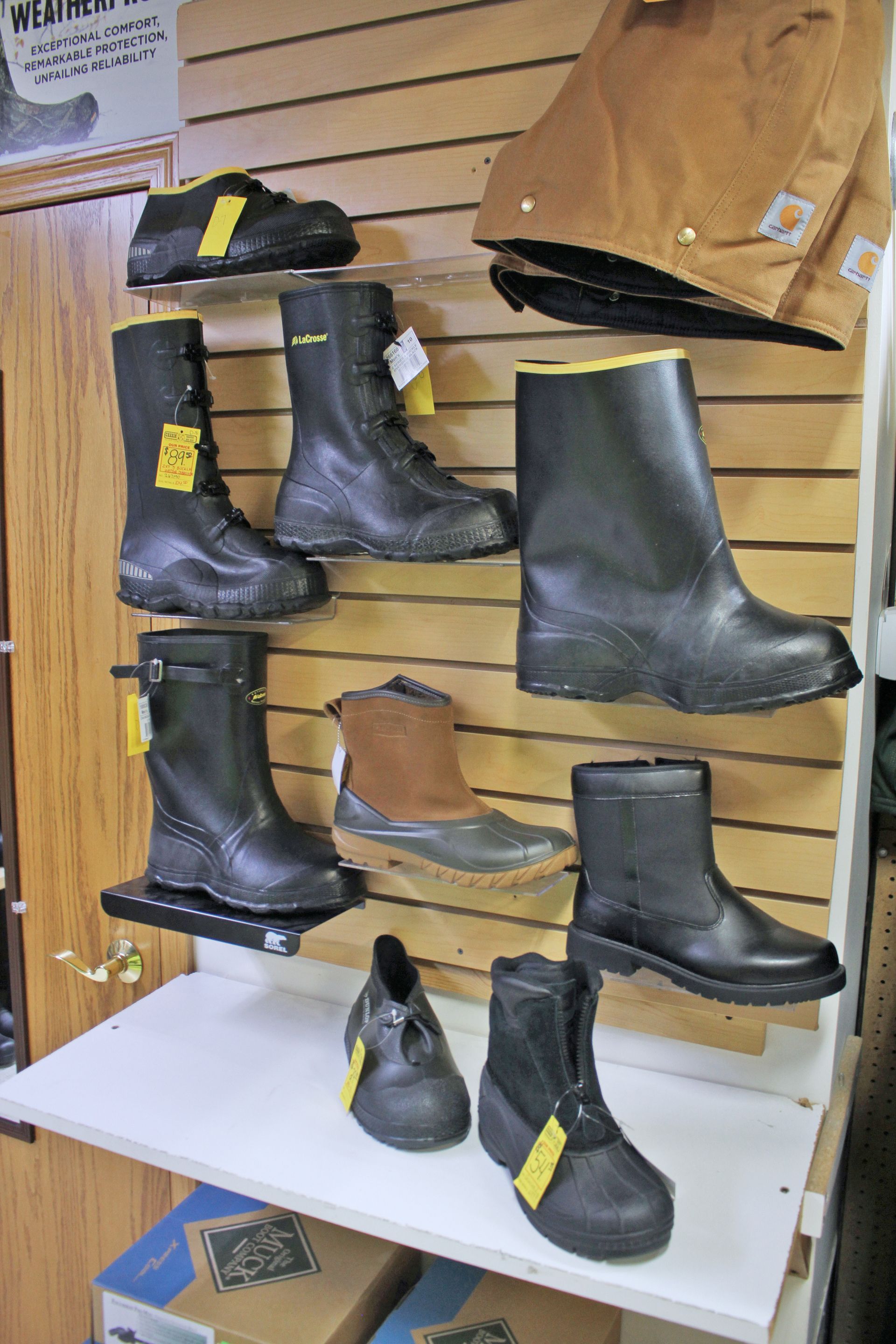 Work boots and outerwear displayed on store shelves.