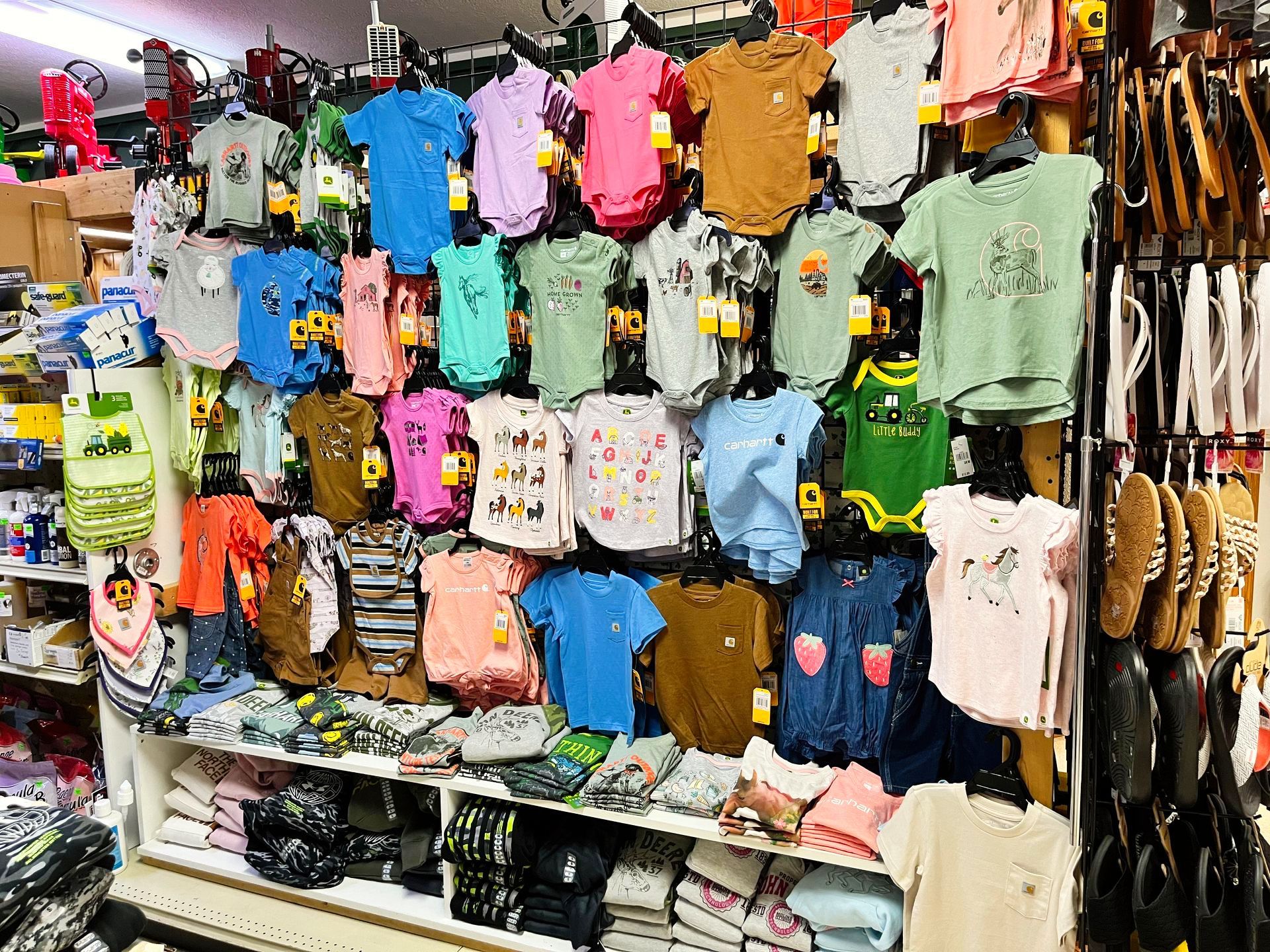 Clothing display with colorful baby clothes on hangers and shelves.