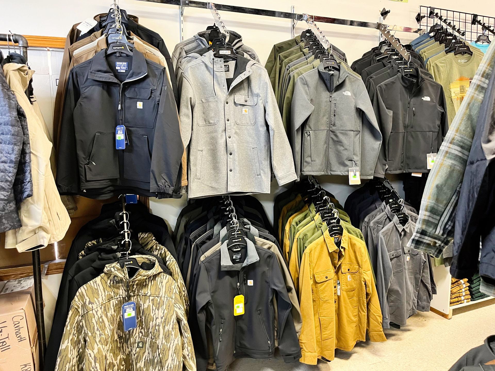 Jackets of various colors and styles hanging on racks in a retail store.