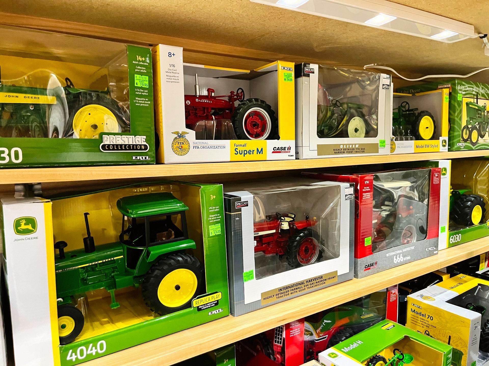 Shelves of toy tractors in boxes, various colors, brands, and models.