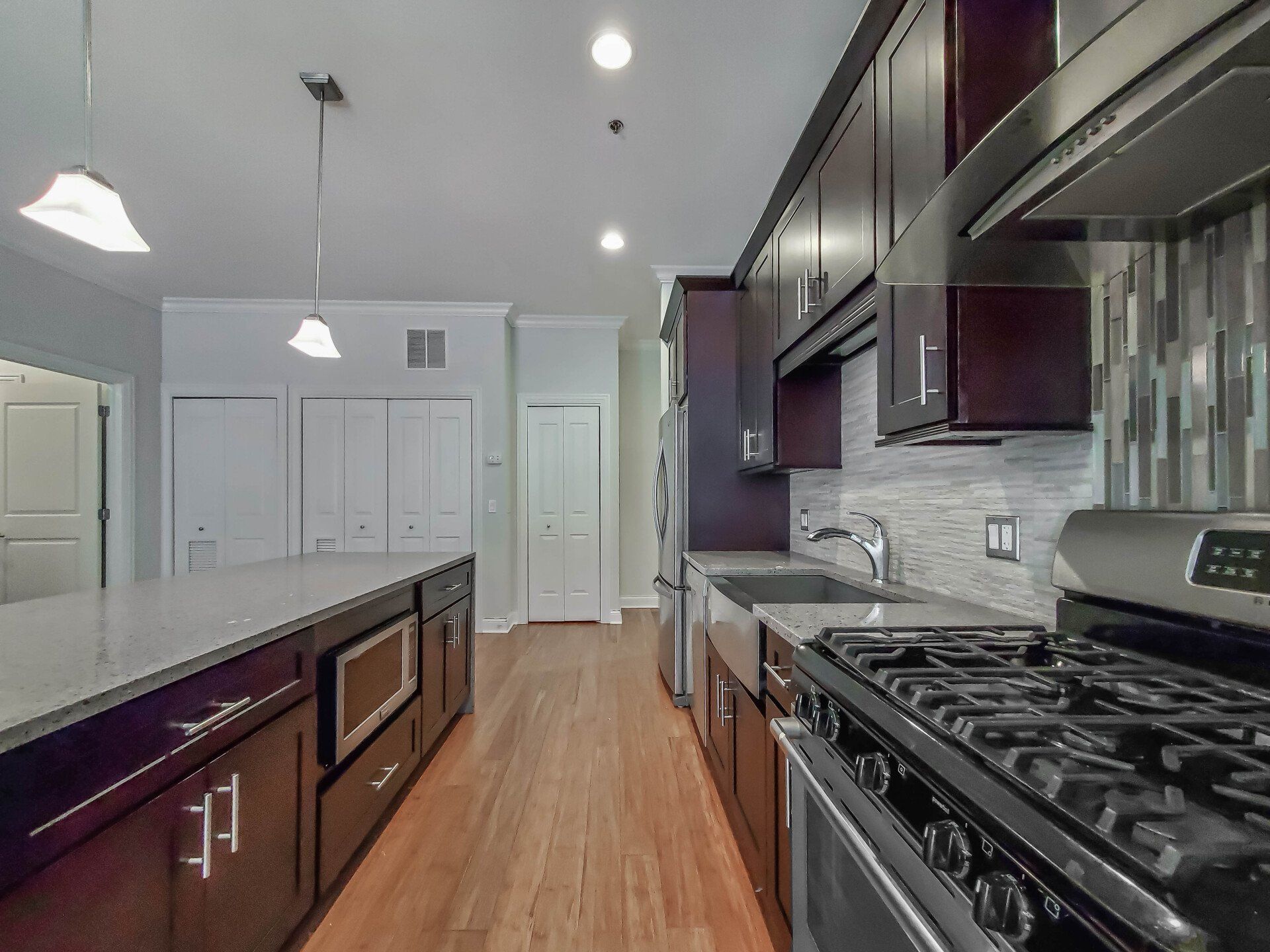 A kitchen with stainless steel appliances and wooden cabinets at Reside on Jackson.