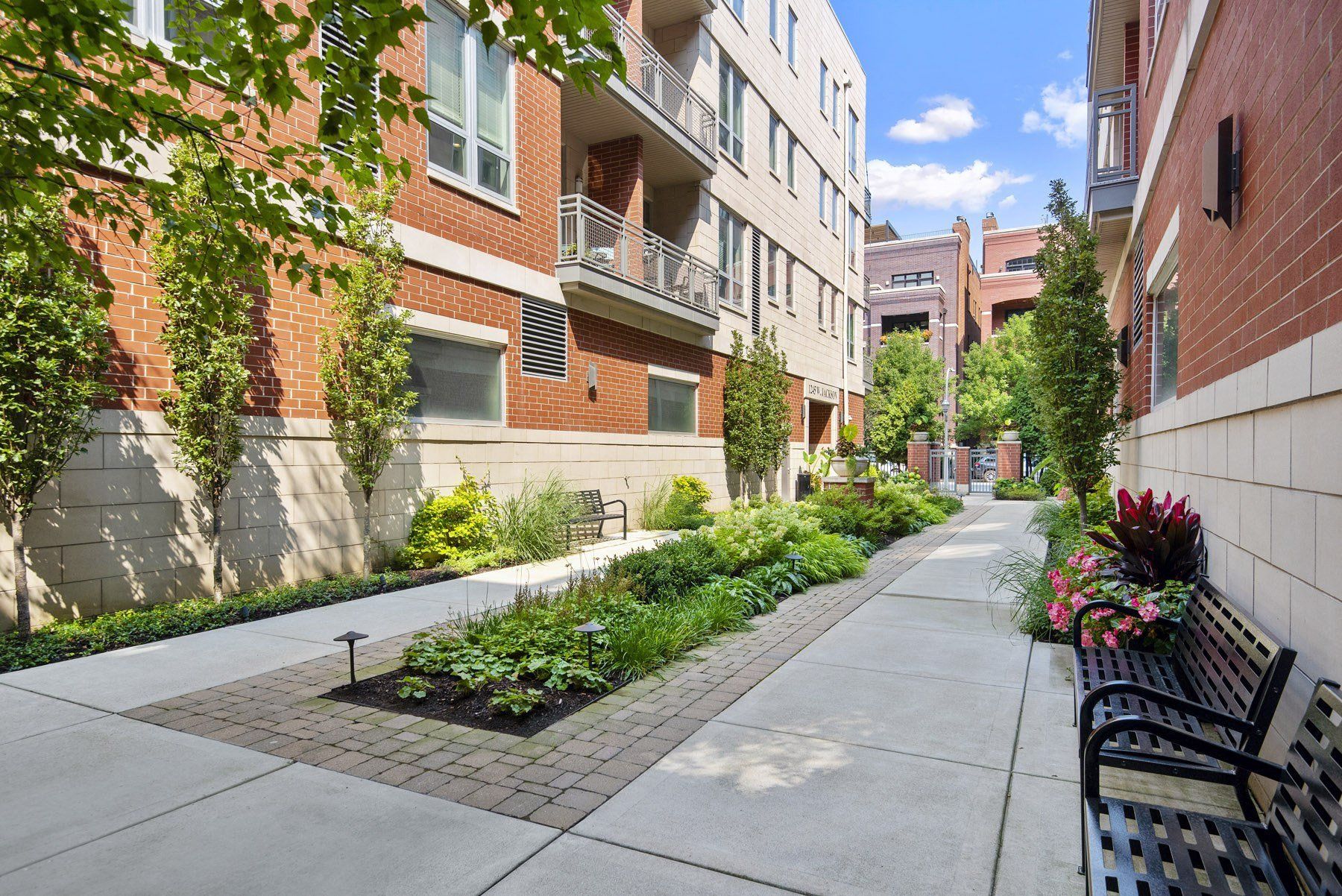 a sidewalk with benches in front of some buildings