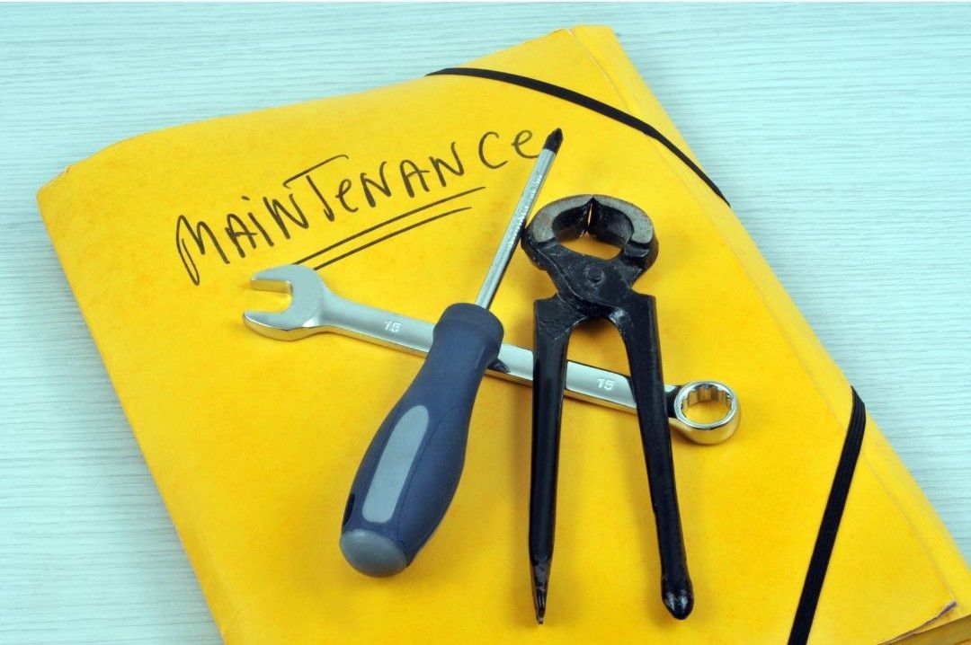 A yellow folder with maintenance written on it