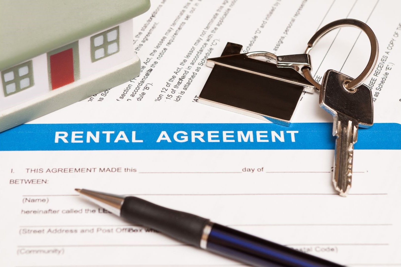 A rental agreement with keys and a pen on it