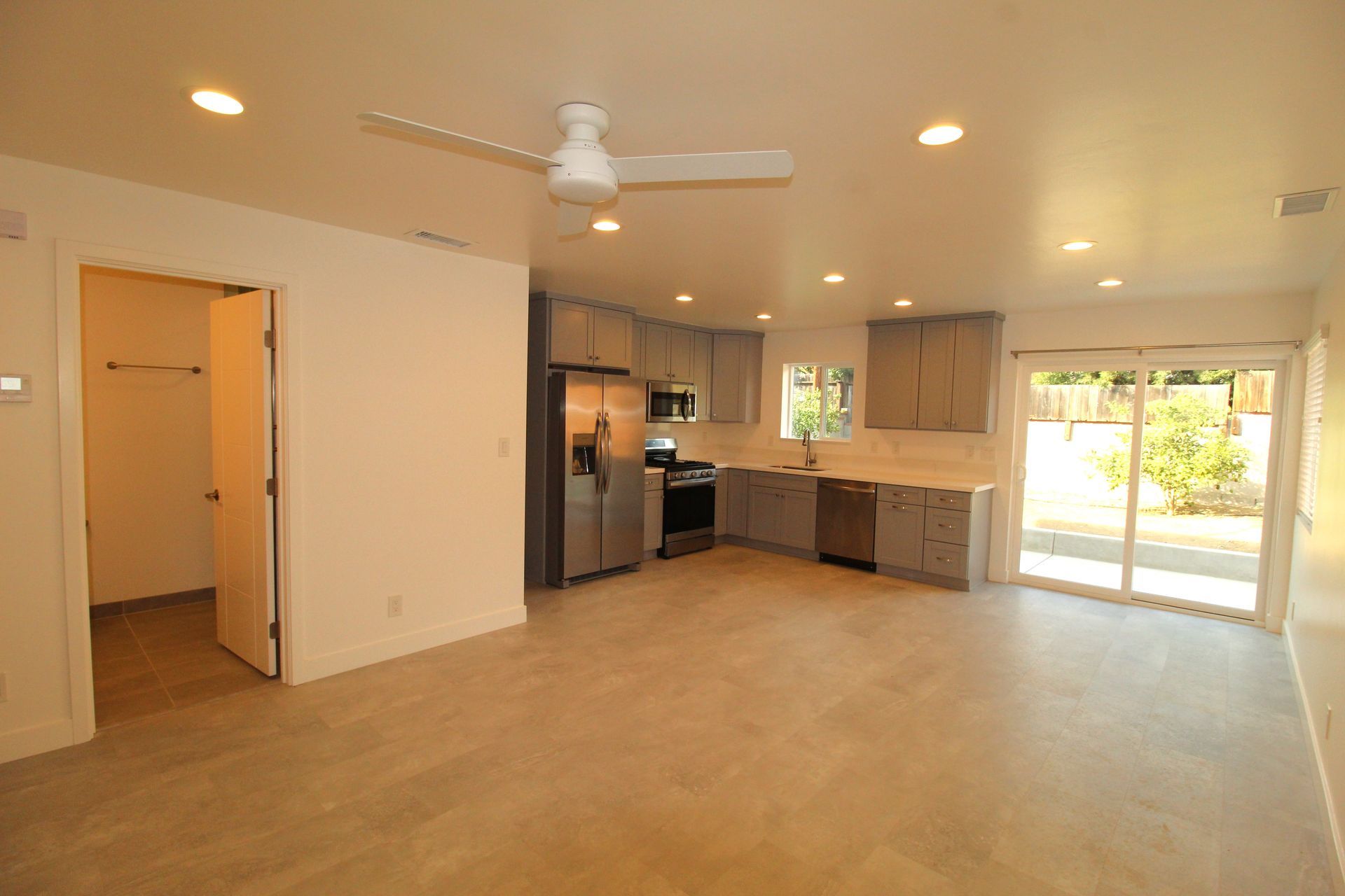 There is a ceiling fan in the living room and a kitchen.