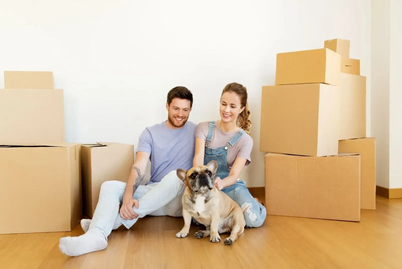 A man and a woman are sitting on the floor with a dog.