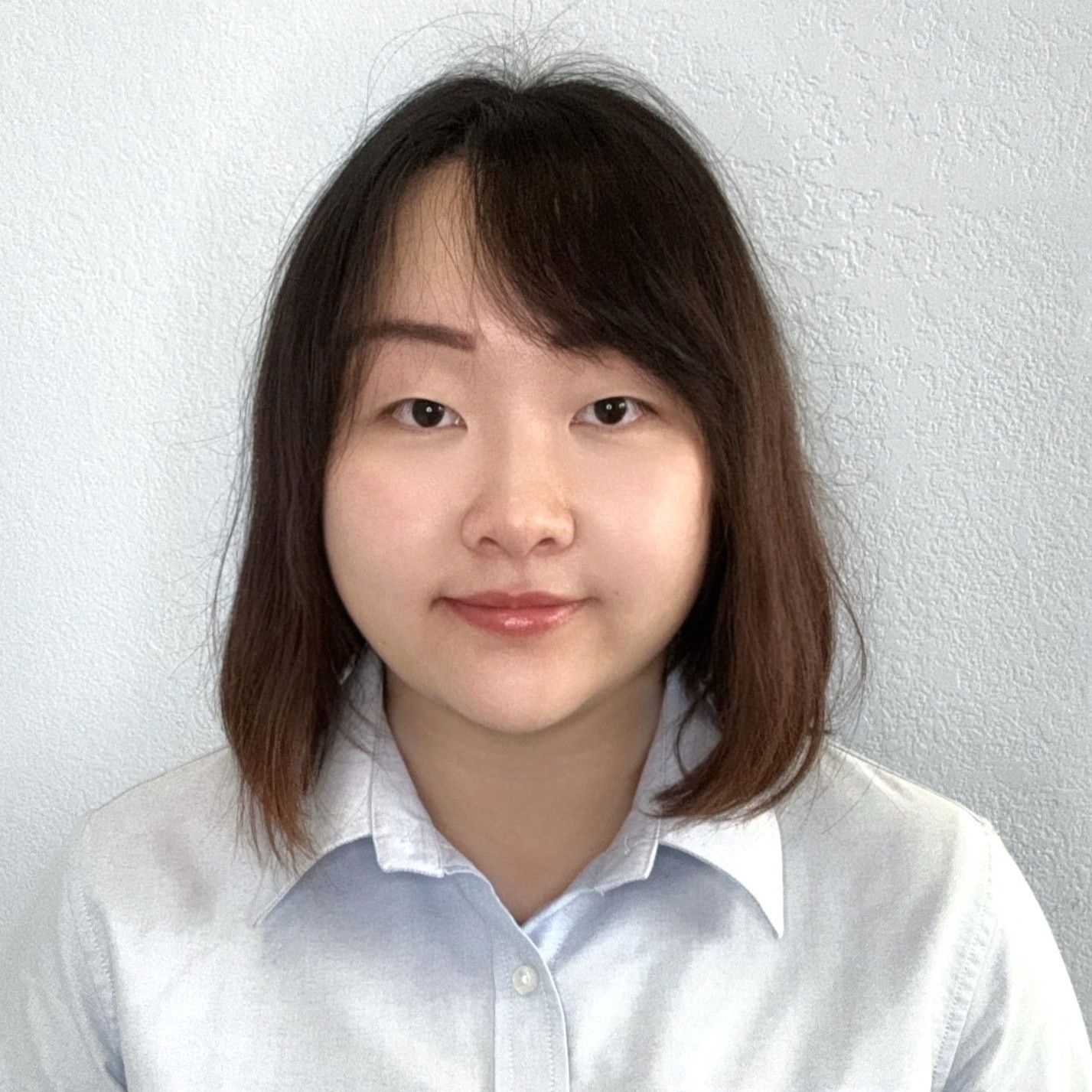 The woman is wearing a white shirt and smiling for the camera.