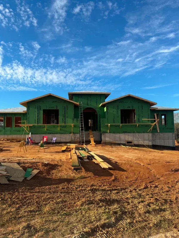 A house is being built in the middle of a dirt field.