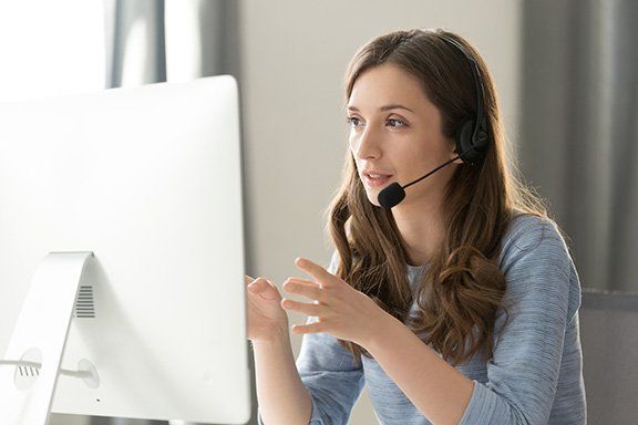 Photo of person in front of computer with headset on