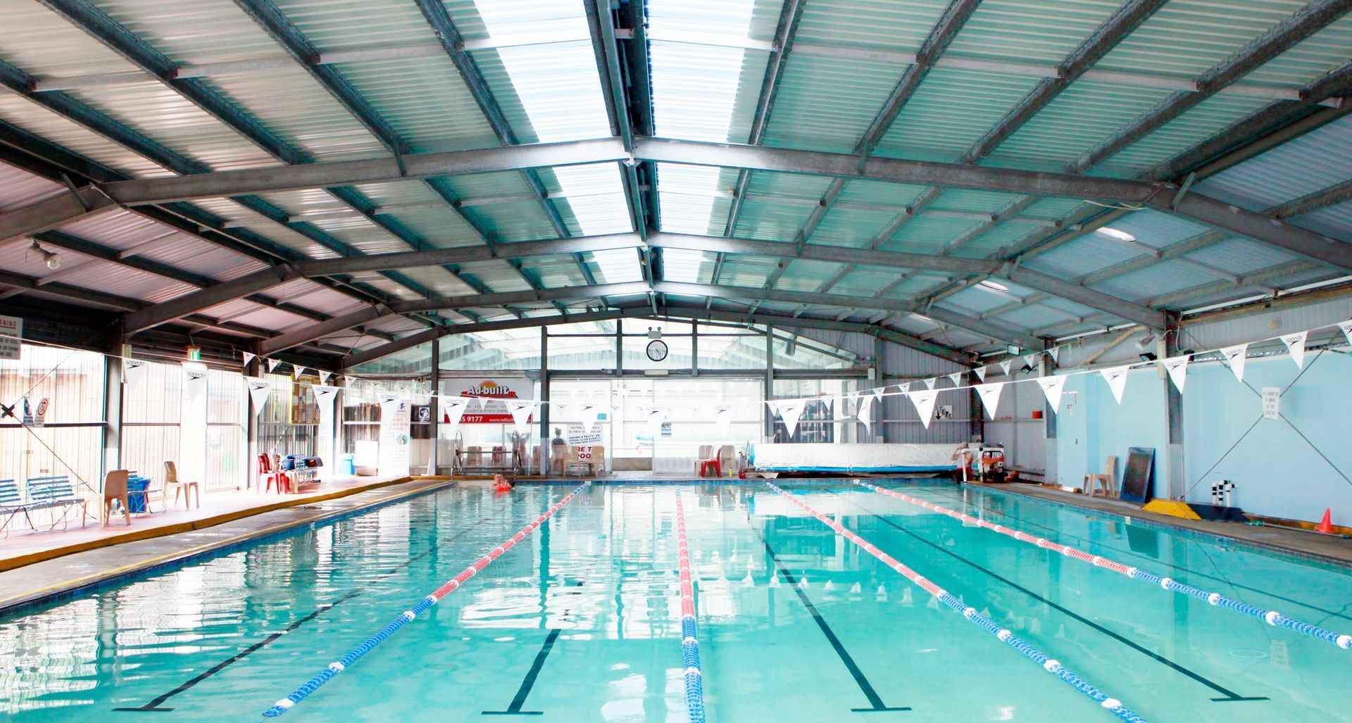 A large indoor swimming pool with a roof and a lot of windows-Swim School In Valentine, NSW