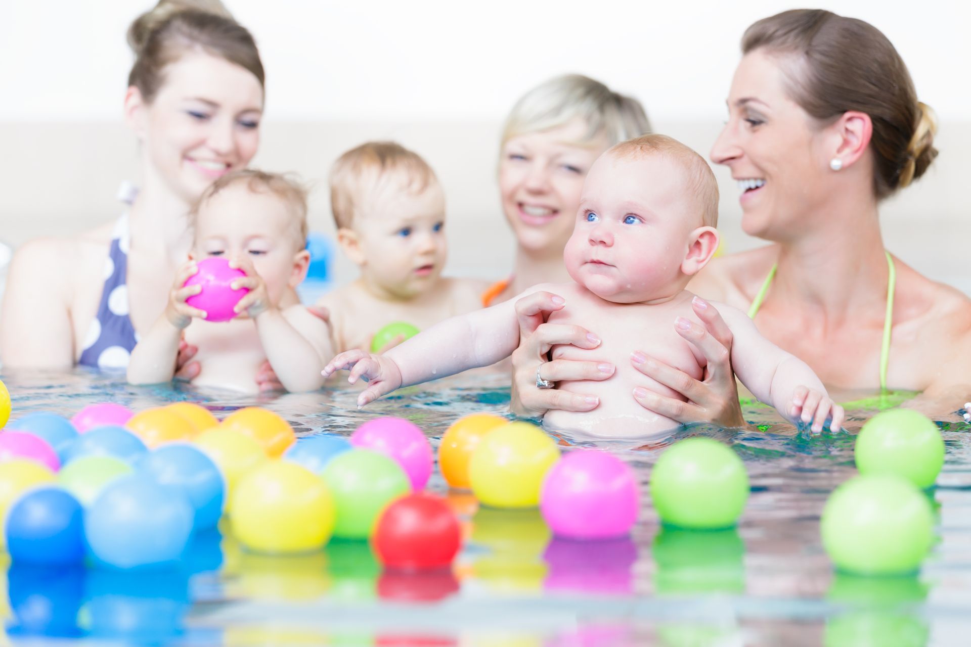 A group of women and babies are playing in a swimming pool-Swim School In Valentine, NSW