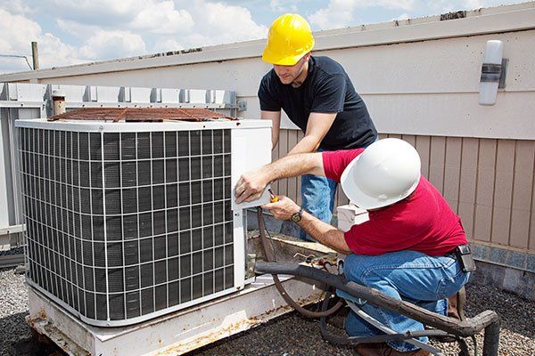 Workers working on the air conditioning unit. Workers working on the air conditioning unit.