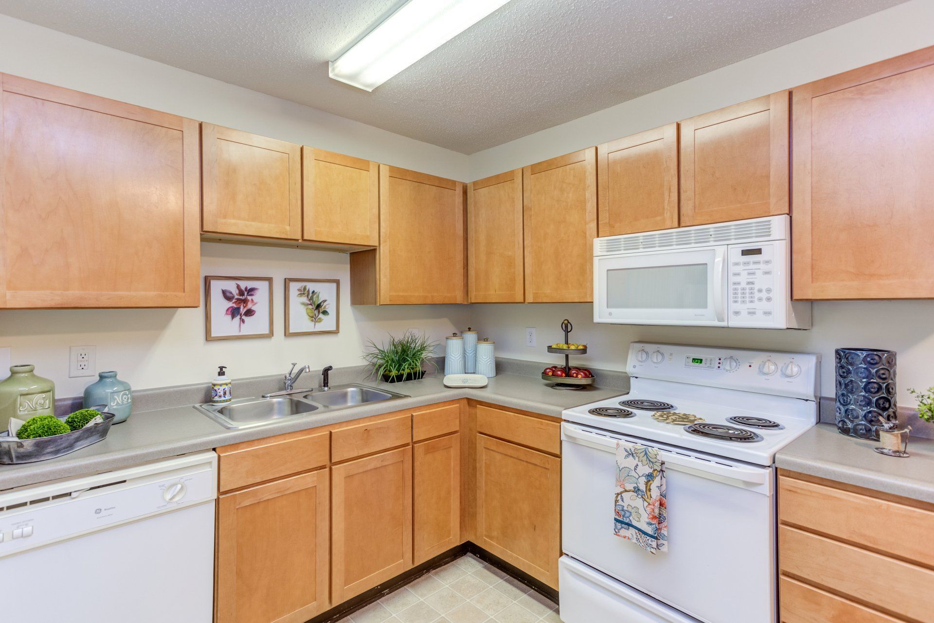 A kitchen with wooden cabinets, a stove, a dishwasher, and a microwave at Morgan Ridge.