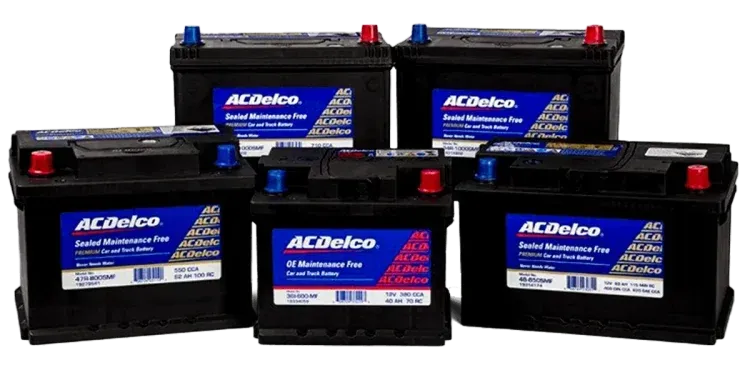 Cinco baterías de automóvil AC Delco negras con terminales azules y rojos.