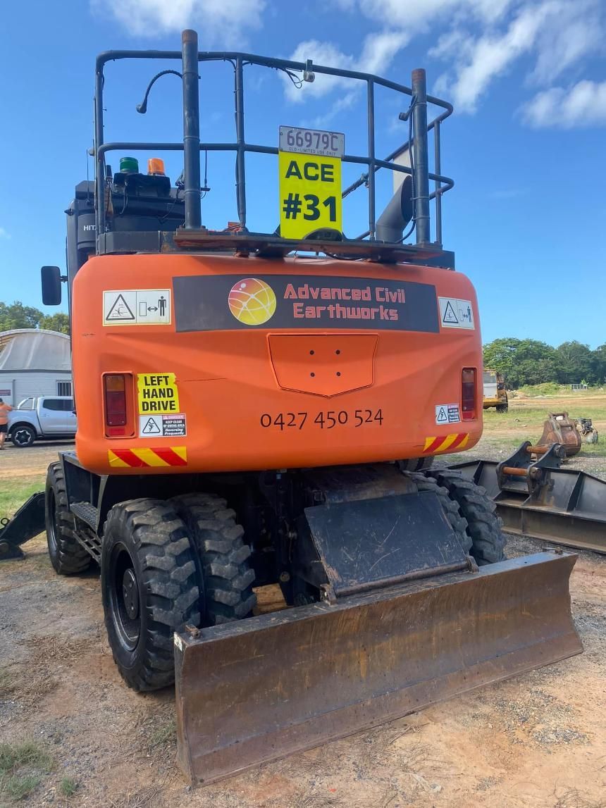 An Orange Excavator With a Yellow Sign on the Back — Advanced Civil Earthworks In Cape York, QLD