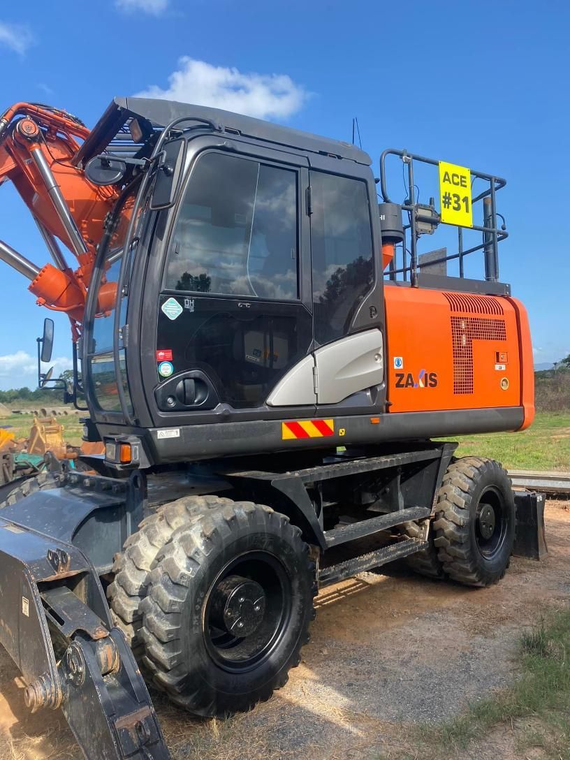 A Large Orange Excavator is Parked in a Dirt Field — Advanced Civil Earthworks In Cape York, QLD