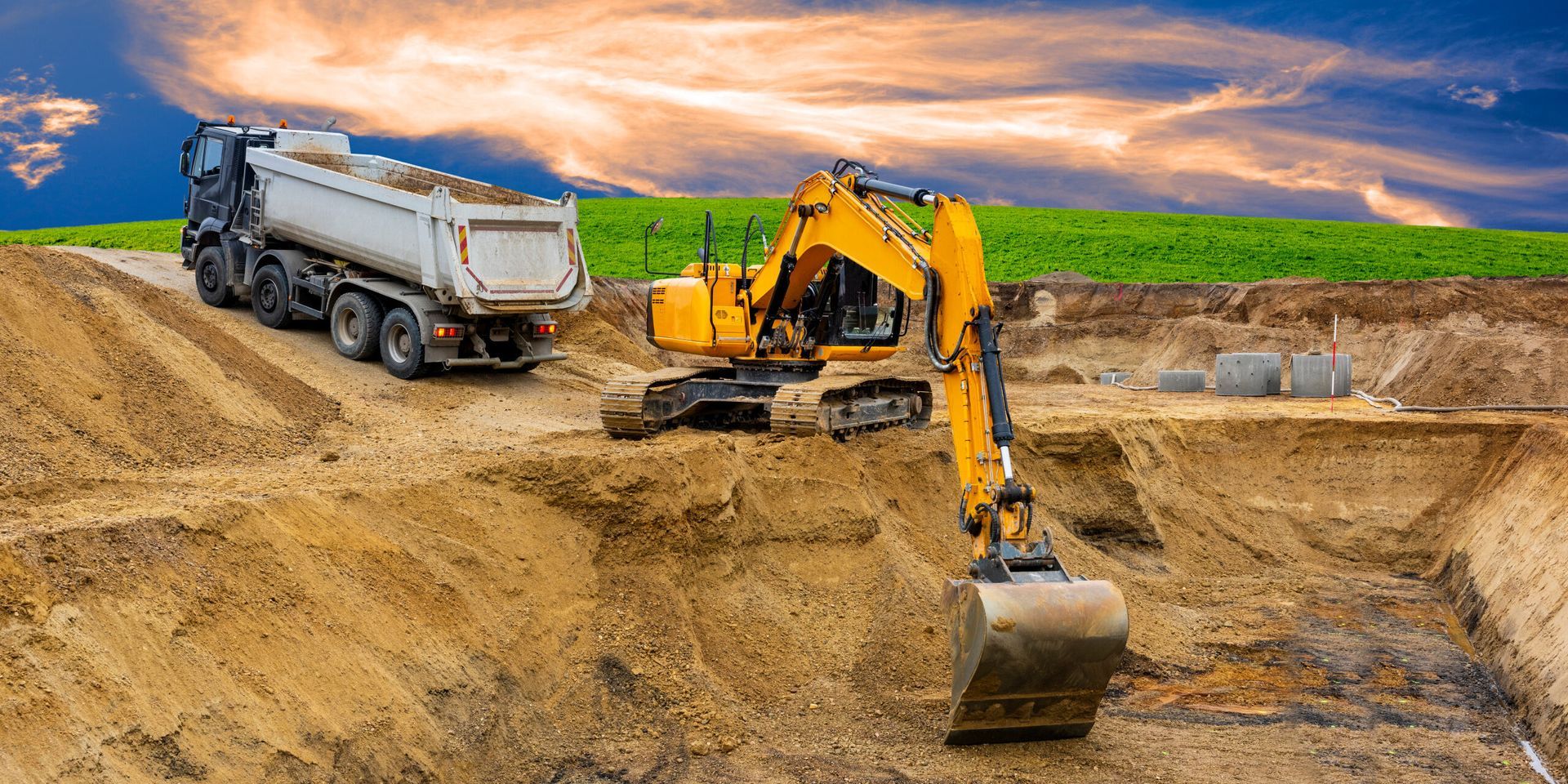 A Dump Truck and an Excavator Are Working on a Construction Site — Advanced Civil Earthworks In Cassowary Coast, QLD
