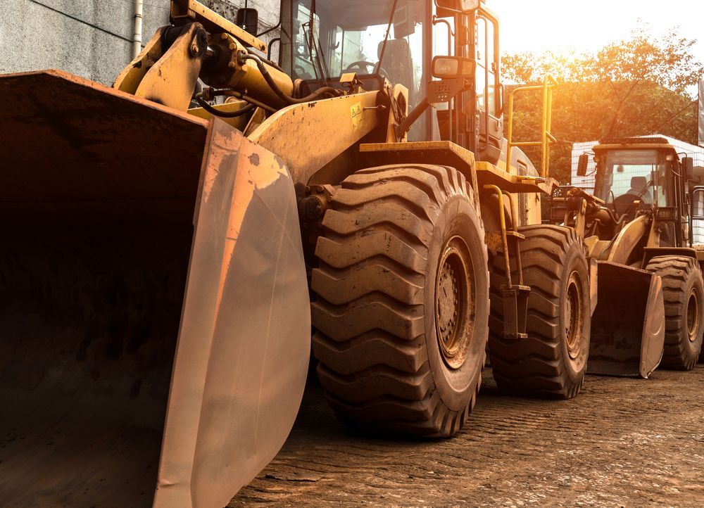 A Row of Construction Vehicles Are Parked in a Parking Lot — Advanced Civil Earthworks In Cassowary Coast, QLD