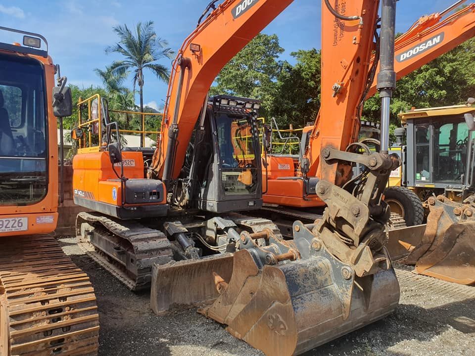 A Large Orange Excavator is Parked Next to a Smaller Orange Excavator — Advanced Civil Earthworks In Mossman, QLD