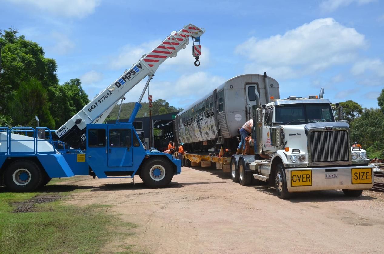 A Truck With a Crane Attached to It is Carrying a Train — Advanced Civil Earthworks In Cooktown, QLD