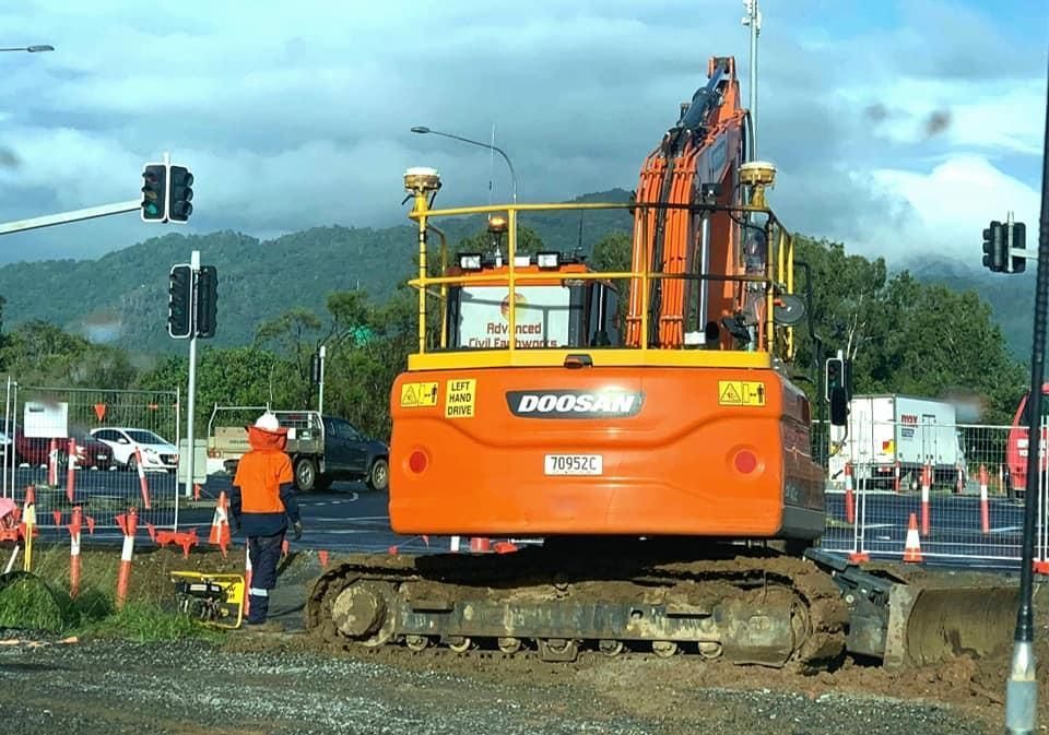An Orange Doosan Excavator is Parked on the Side of the Road — Advanced Civil Earthworks In Port Douglas, QLD