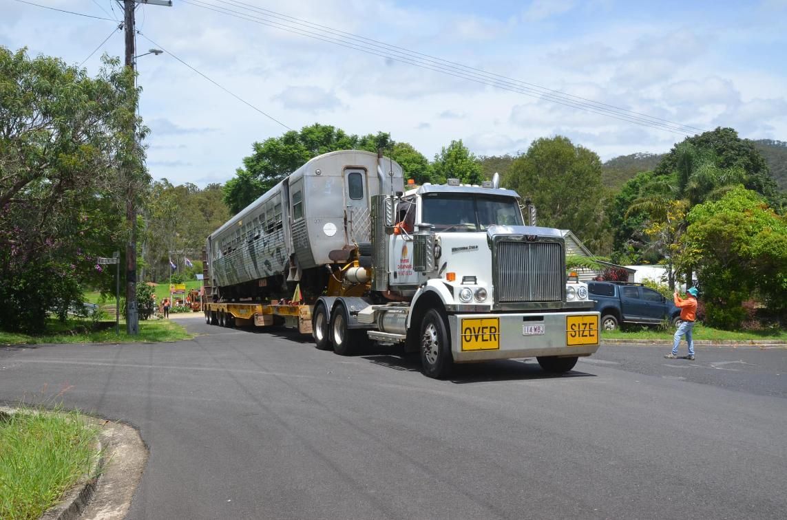 A Semi Truck is Carrying a Train Down a Street — Advanced Civil Earthworks In Cairns, QLD