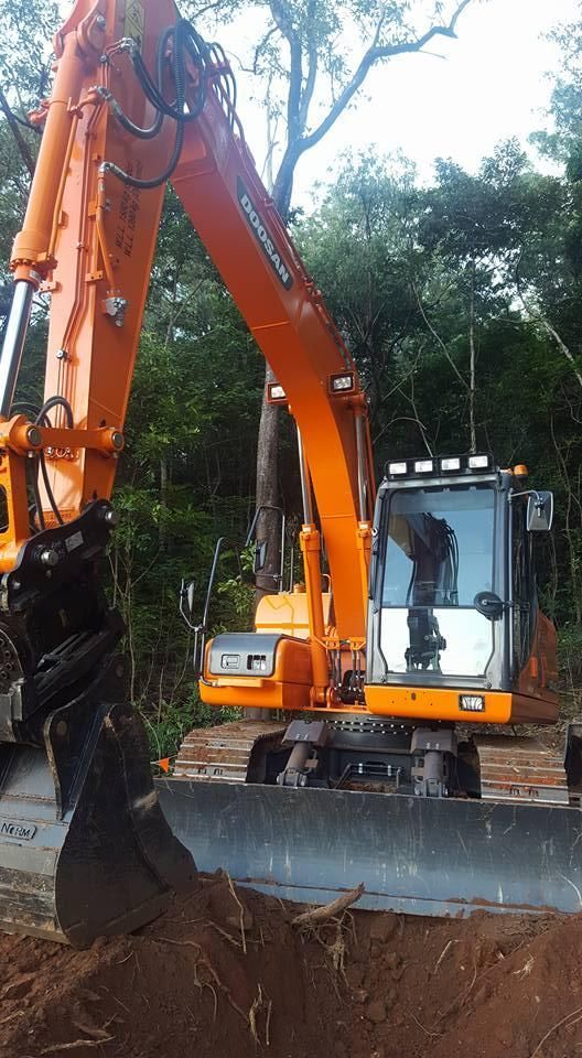 A Large Orange Excavator is Digging a Hole in the Ground — Advanced Civil Earthworks In Cooktown, QLD