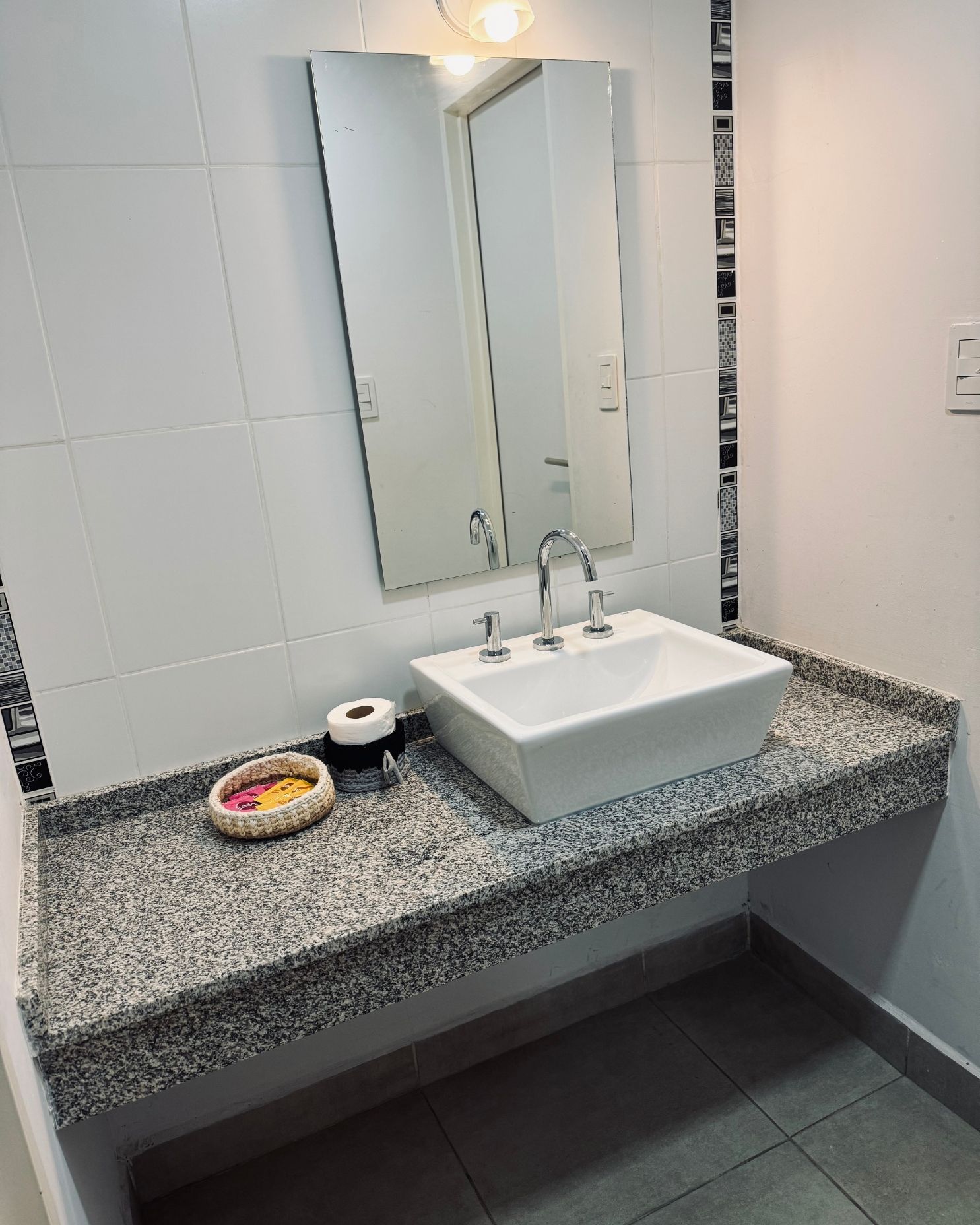 A bathroom with a sink and a mirror on the wall