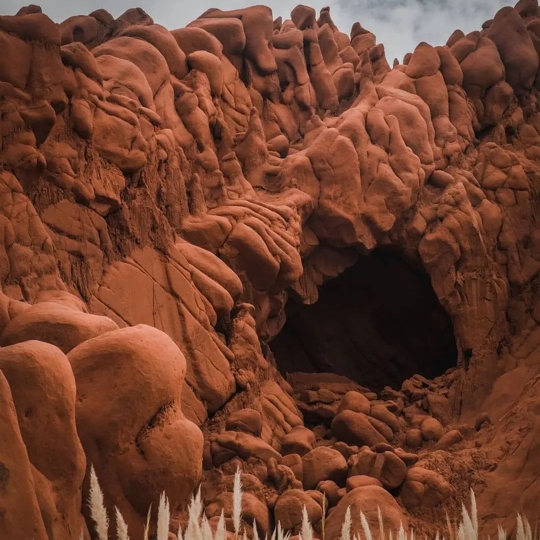 A large rock formation with a cave in the middle of it