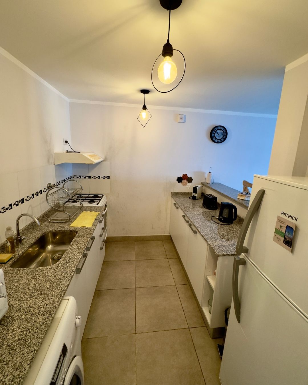 A kitchen with granite counter tops and a white refrigerator