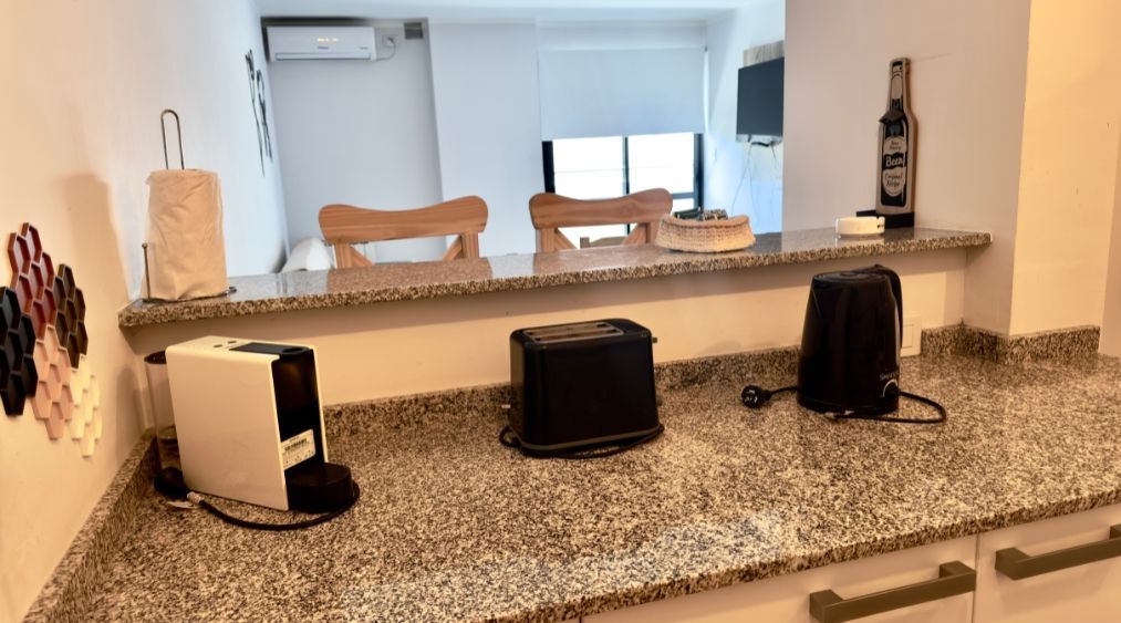 A kitchen counter with two toasters and a coffee maker