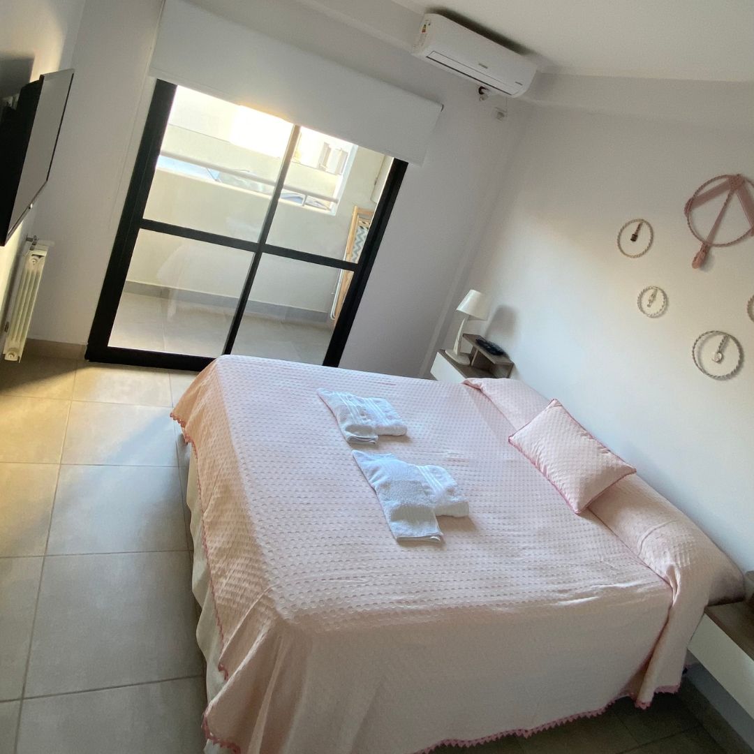 A bedroom with a large bed and a sliding glass door