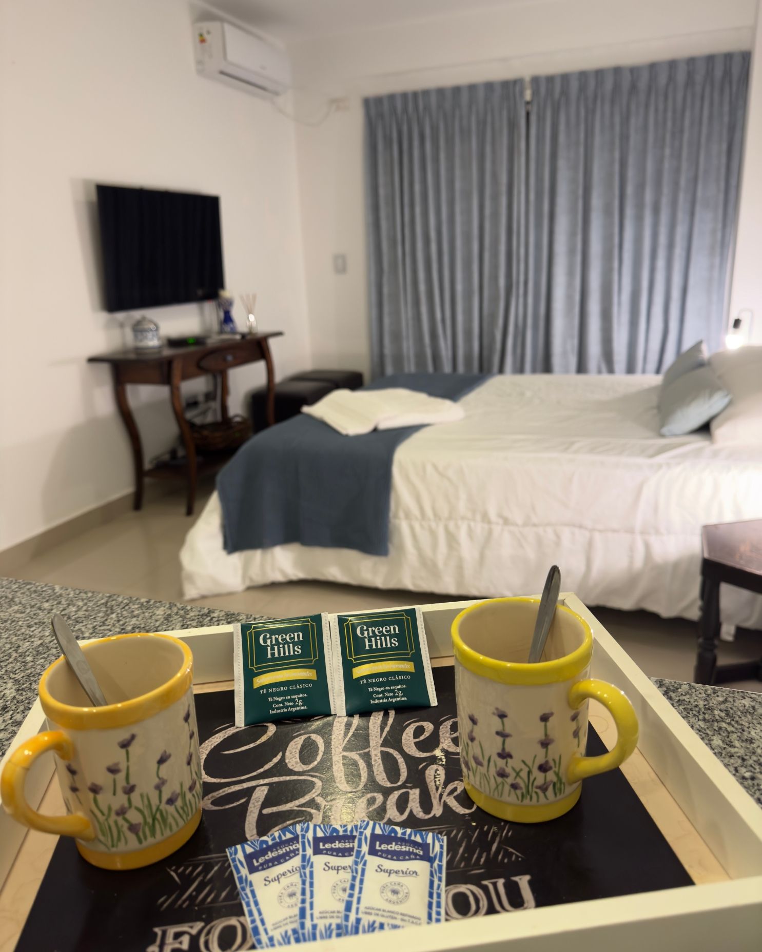 A room with a bed and a tray that says coffee break
