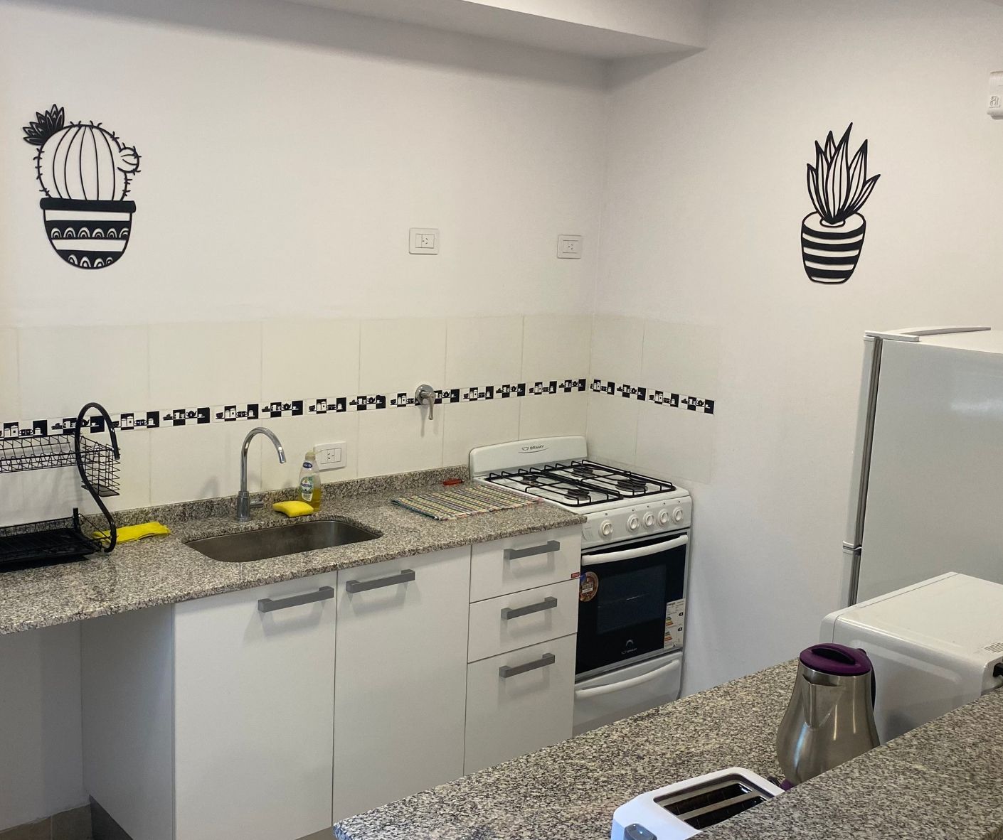 A kitchen with a stove , sink , and refrigerator