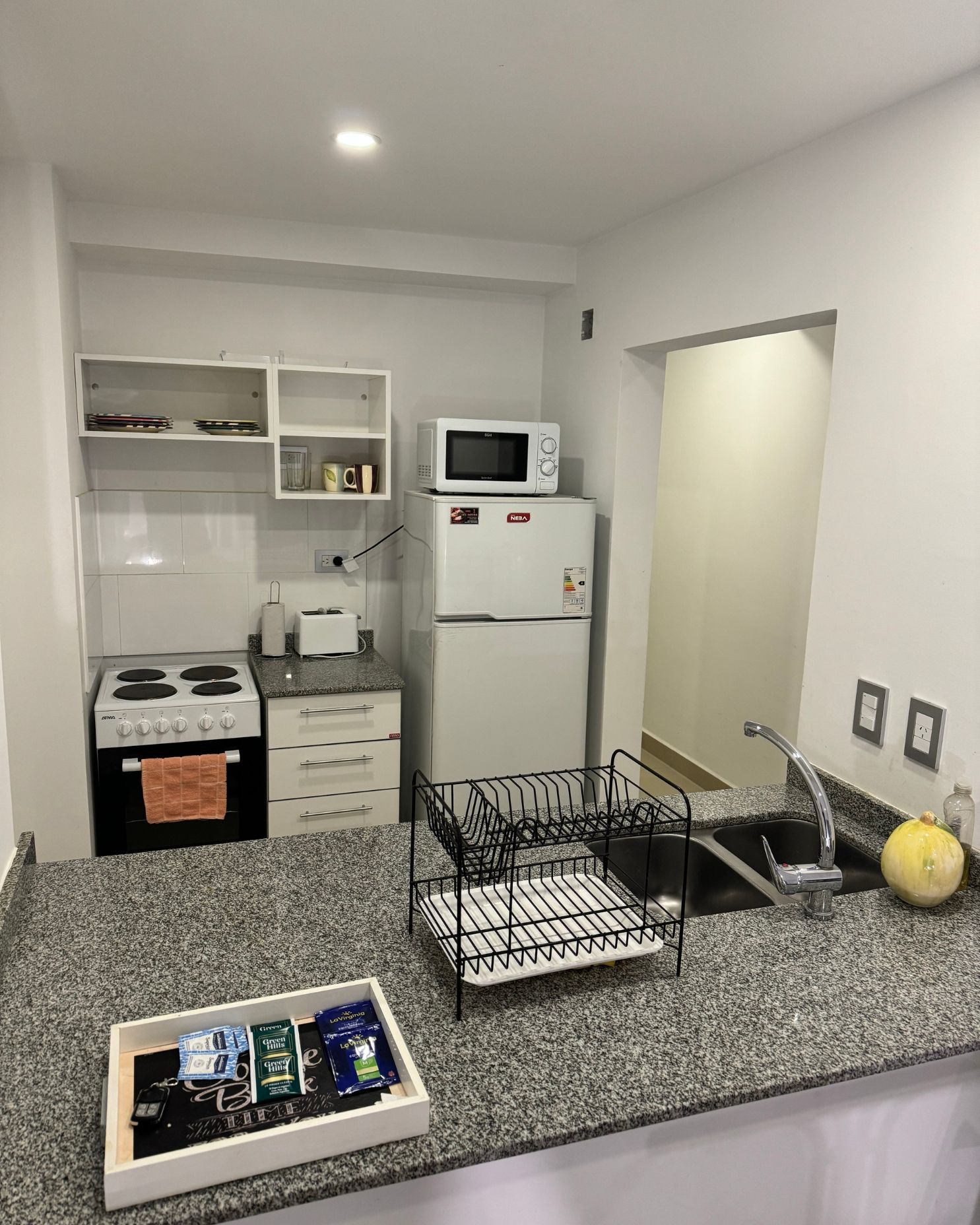 A kitchen with a refrigerator , microwave , sink and stove.