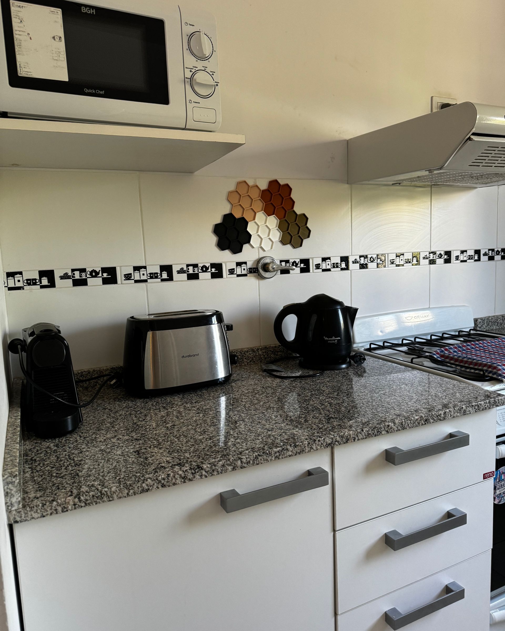 A kitchen with granite counter tops and white cabinets