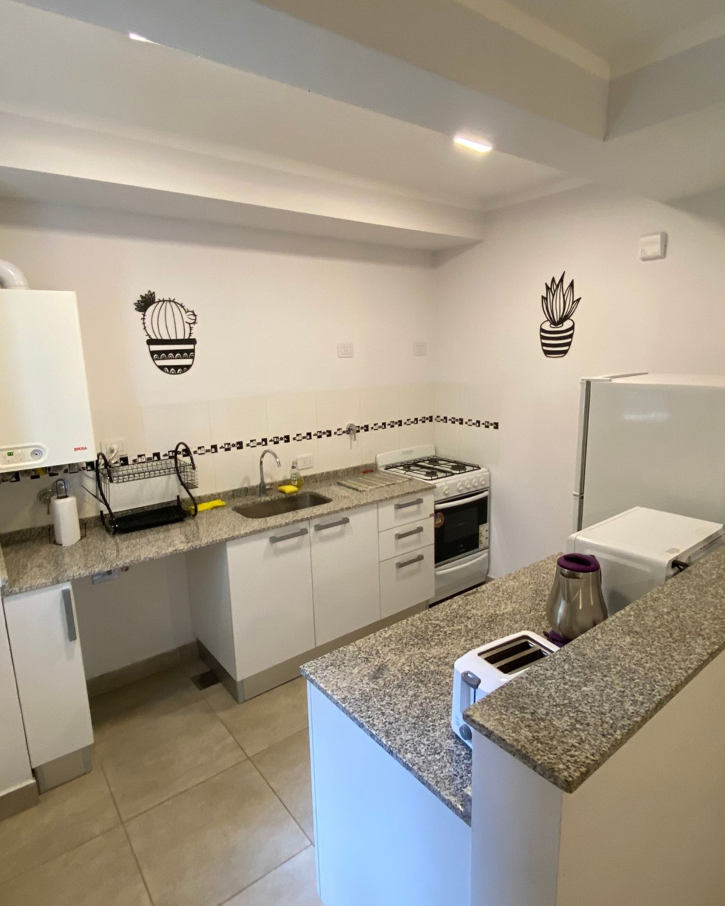 A kitchen with granite counter tops and white cabinets